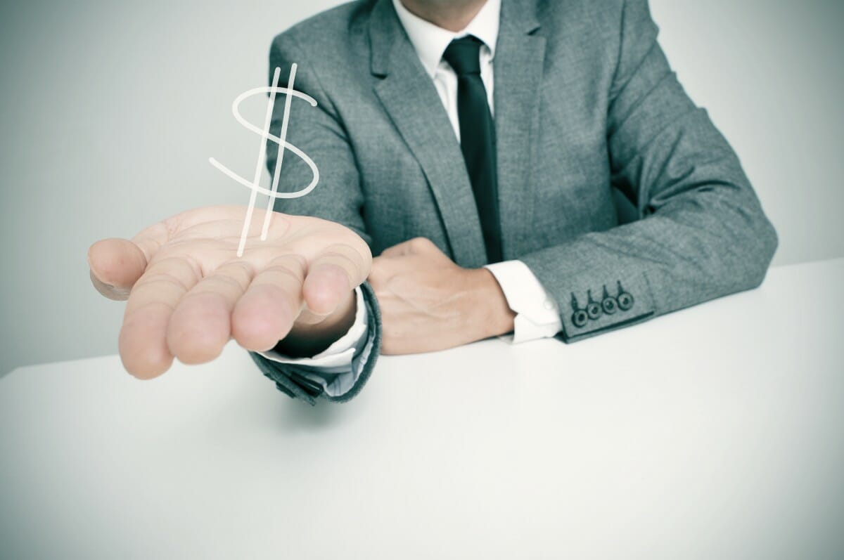 businessman sitting desk showing drawn dollar sign | Are Bonuses Taxed Differently Than Commissions? | Tax Rate on Bonuses | tax rate on bonuses | tax rate for bonuses
