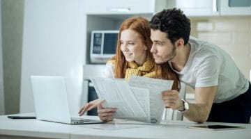 young couple calculating their bills | IRS Form 8962 [Calculate Premium Tax Credit] | irs form 8962 | form 8962 instructions | Featured