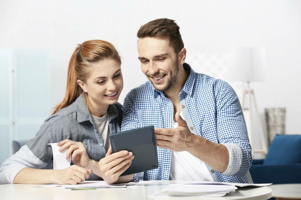 young couple looking at tablet | IRS Form 8962 [Calculate Premium Tax Credit] | irs form 8962 | how to fill out a 8962 tax form