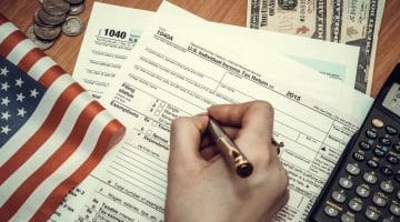 Featured | Business woman fills tax forms | IRS Tax Forms by State | A Comprehensive Guide | taxes