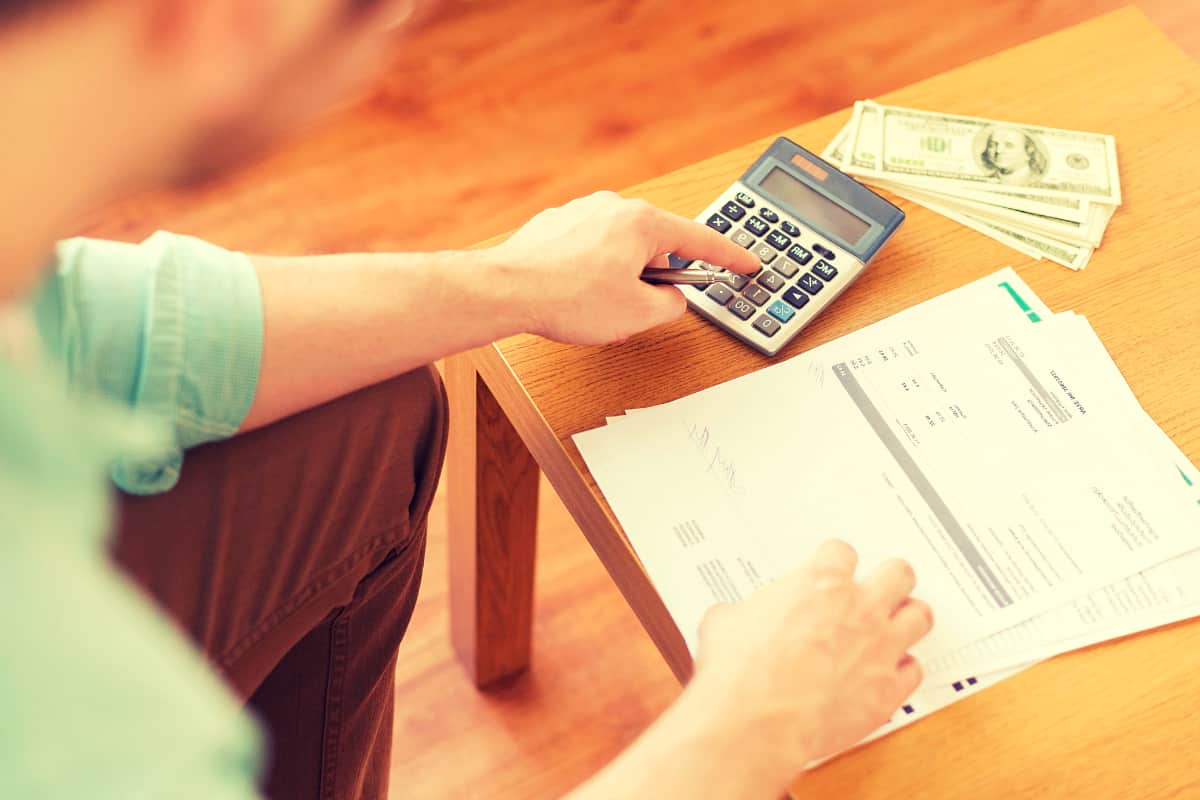 man checking expenses | The Master List of All Types of Tax Deductions | types of tax deductions | list of tax deductions