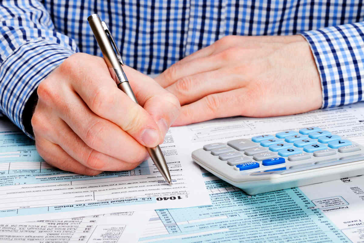 Taxpayer filling out 1040 Tax Form | What Is The Tax Date And How You Should Prepare