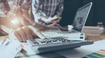 Feature | man using calculator | Tax Deductions and Tax Writeoffs Guide | Tax Writeoff Blog Roundup | What Is Tax Deductible?
