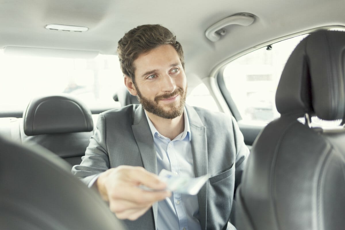 man paying taxi | What Qualifies As Deductible Business Expenses