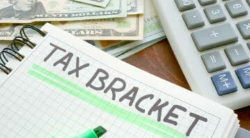 Feature | tax bracket written on notebook | Everything You Need To Know About 2018 Tax Brackets (And What They Tell Us About 2019)