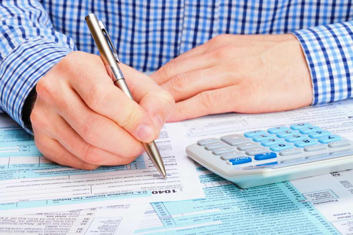 tax payer filling out 1040 tax form | Everything You Need To Know About 2018 Tax Brackets (And What They Tell Us About 2019)
