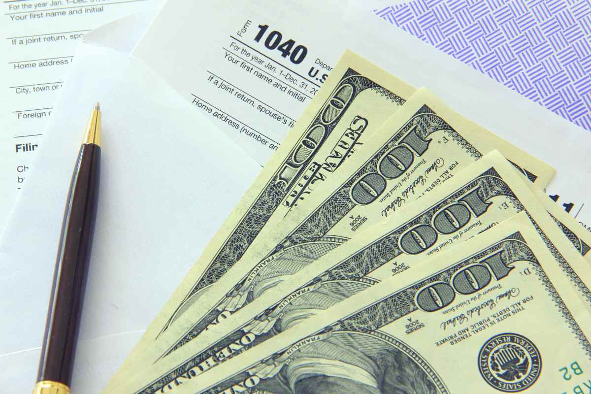 Tax papers in an envelope with 100 dollar bills | Easy Ways To Avoid An IRS Tax Lien | Federal tax lien 
