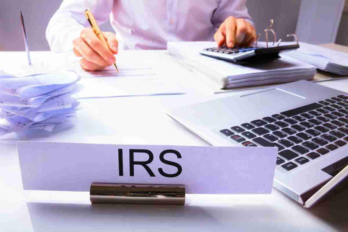 IRS auditor writing and calculating | What To Do When You Owe Back Taxes