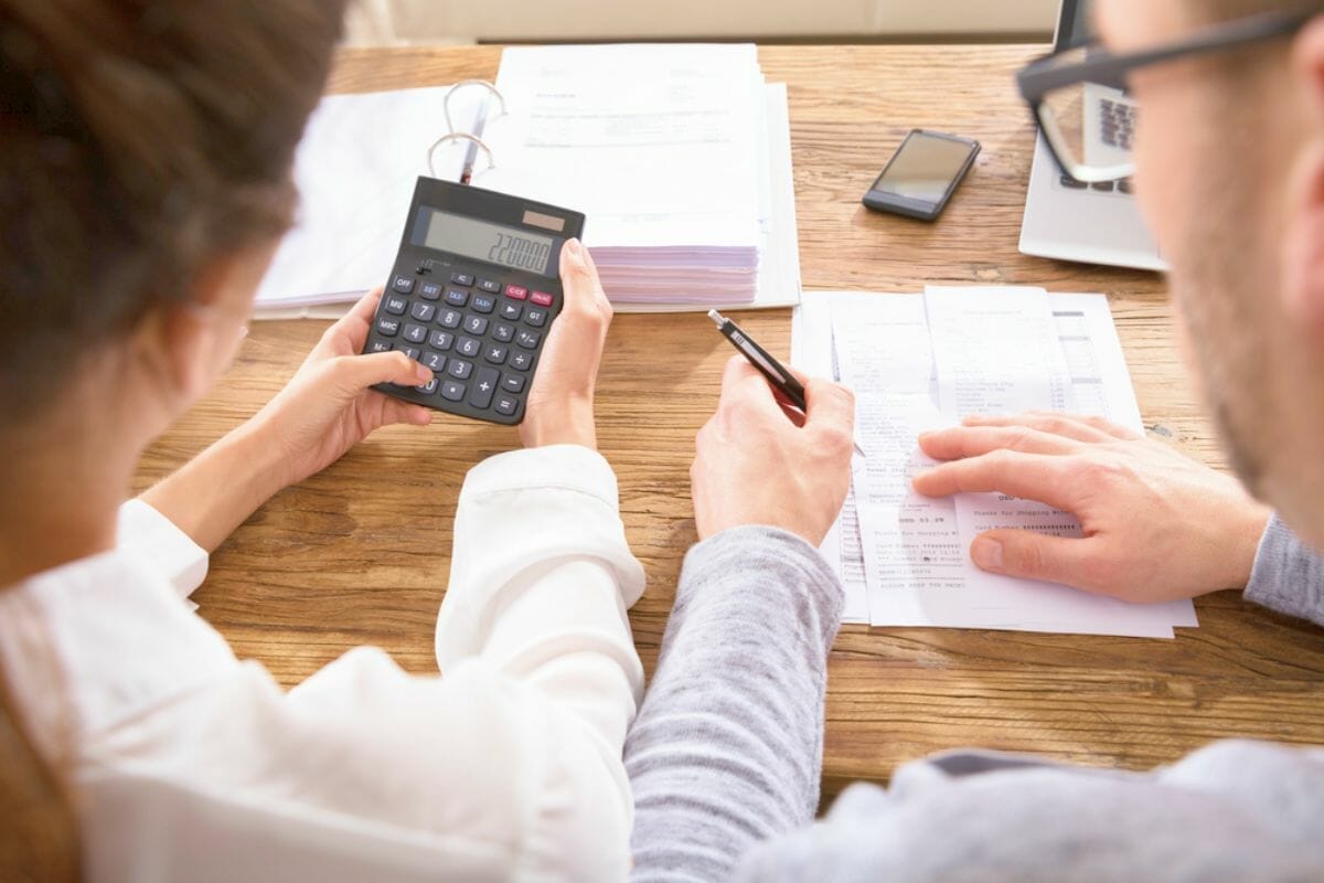 Closeup couple calculating bill using calculator | IRS Penalty Calculator: Breaking Down Your IRS Late Fees | IRS payment plan form