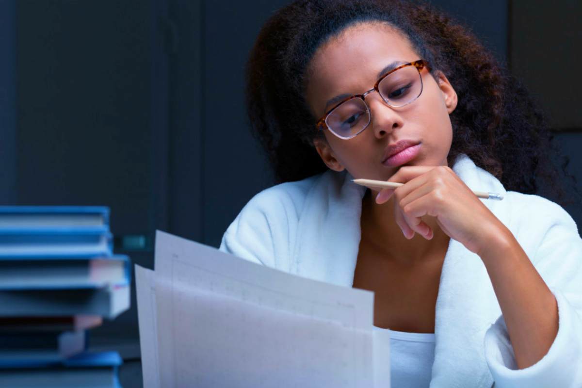black girl reading document | The Pros And Cons Of Filing A Tax Extension | file tax extension