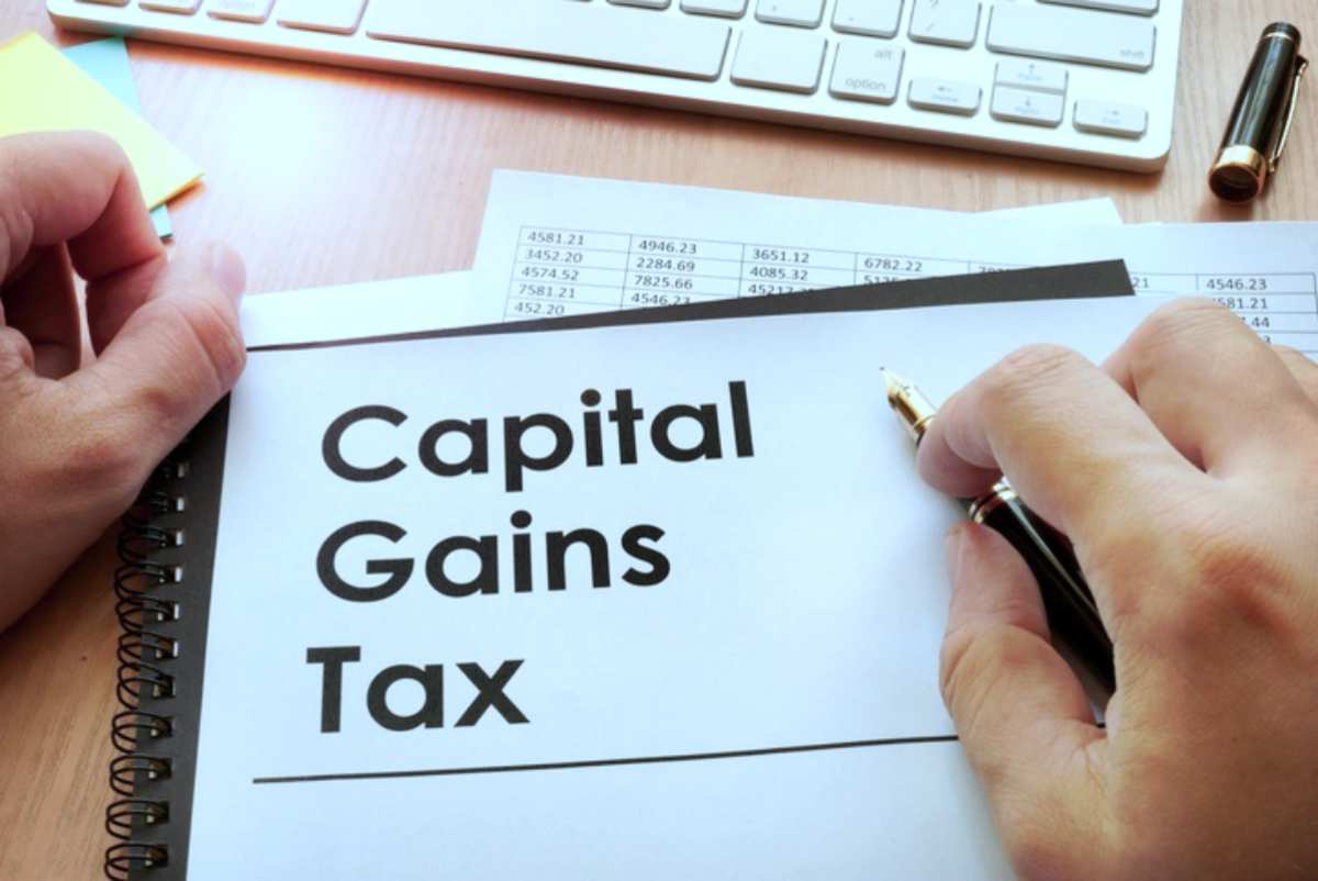 Hands holding documents title capital gains | Different Types Of Taxes We Pay In The US | IRS