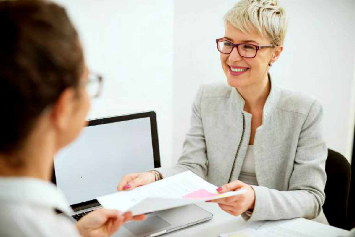 Woman discussing tax document in the office | Things NOT To Say To The IRS If You Owe Back Taxes