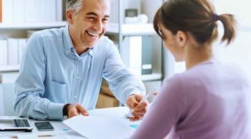 young woman having business meeting signing | Qualifications for the IRS Fresh Start Program | fresh start program | irs fresh start | Featured