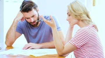 Feature | worried young couple checking on bills | Tips to Avoid Wage Garnishment | wage garnishment