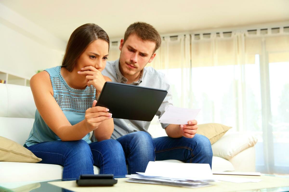 worried couple checking bank account | What To Do If The IRS Wage Garnishment Is Causing Hardship | stop wage garnishment