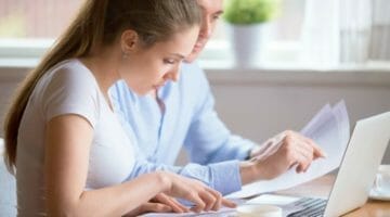 Feature | young couple looking at document | Top Questions About the IRS Fresh Start Program | irs fresh start program