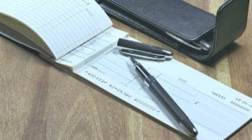 Feature | cheque book and pen | IRS Penalties For A Bounced Check | bounced check to irs