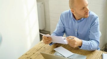 Feature | businessman reading letter | What Is An IRS Tax Offset and How Do You Recover It? | treasury offset program