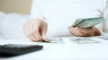 Featured | person counting money | How Much Taxes Do I Owe The IRS? | how much do i owe the irs