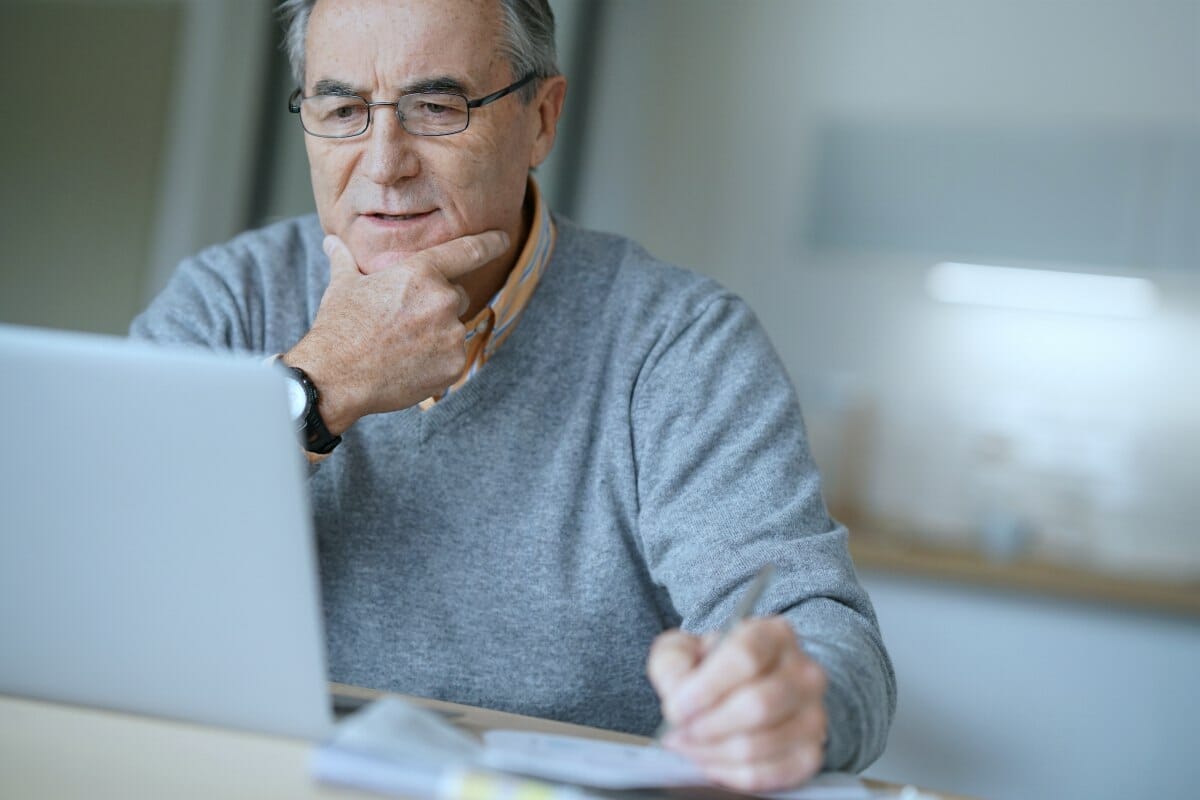 man looking at his laptop | Rejected Offer In Compromise: How To Negotiate With The IRS | How to lower taxes