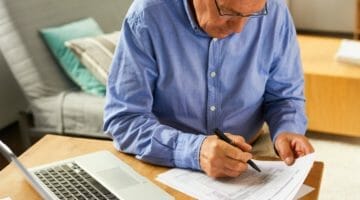 senior man filing taxes | Do I Have To File State Taxes Even If I Don’t Owe Anything? | do I have to file state taxes | file state taxes | Featured