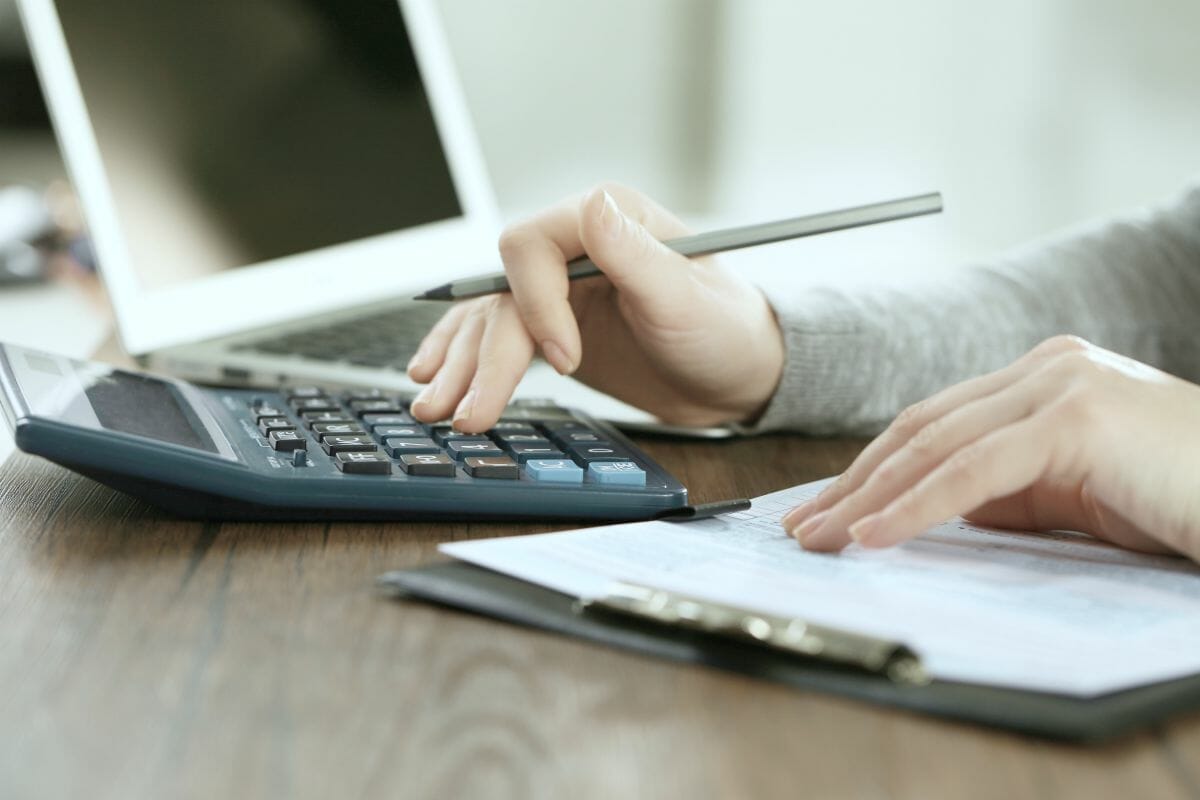 woman using calculator | Tax Considerations According To Type Of Business Ownership | types of business ownership | different types of businesses